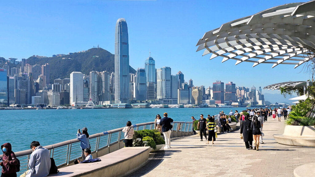 Vedere panoramică a Avenue of Stars din Hong Kong, cu orașul și portul în fundal.