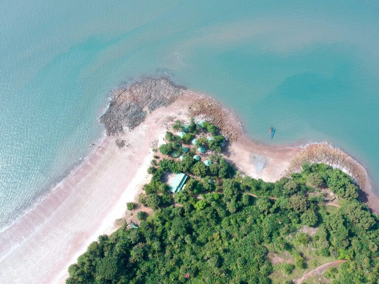 Tropical beach in Bissau, Guinea-Bissau, with turquoise waters and lush vegetation.