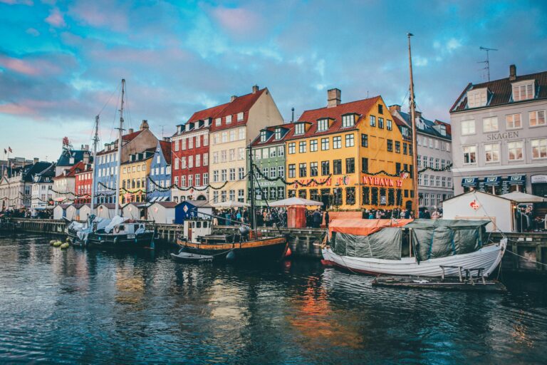 Canalul Nyhavn cu clădiri colorate și bărci în Copenhaga