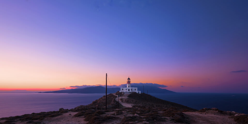 Farul Armenistis în apus, situat pe insula Mykonos, Grecia.