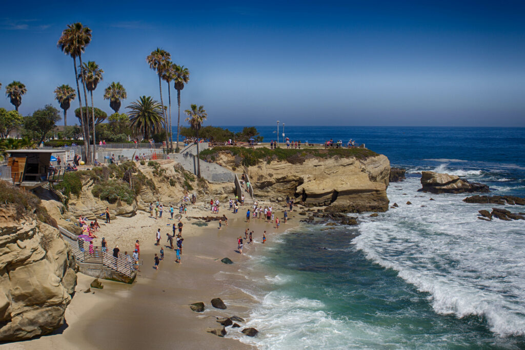 La Jolla Cove din San Diego cu turiști pe plajă și vedere la ocean.