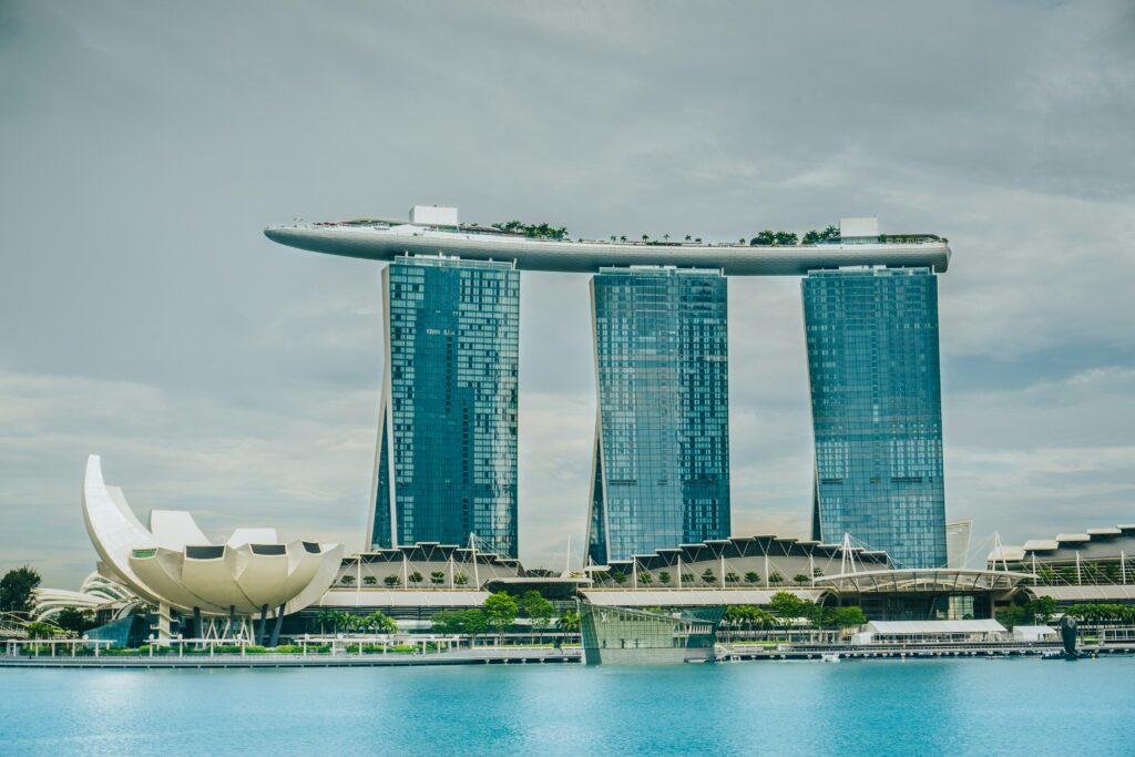 Marina Bay Sands din Singapore, văzută în timpul zilei, cu apă albastră în prim-plan și cer senin.