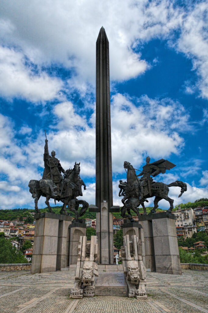 Monumentul Asenevtsi din Veliko Tarnovo, călăreți din bronz și obelisc în mijlocul unei peisajului pitoresc.