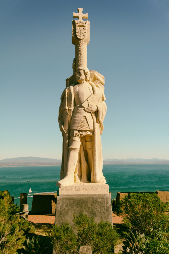 Statuia lui Juan Rodriguez Cabrillo, amplasată la Cabrillo National Monument cu oceanul în fundal.