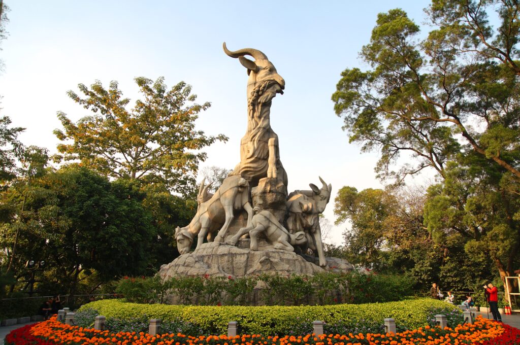Statuia Celor Cinci Capre în Parcul Yuexiu din Guangzhou, o atracție simbolică înconjurată de natură și flori.