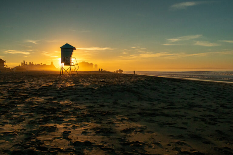 Apus de soare la Coronado Beach, San Diego, cu turn de salvamar în fundal.