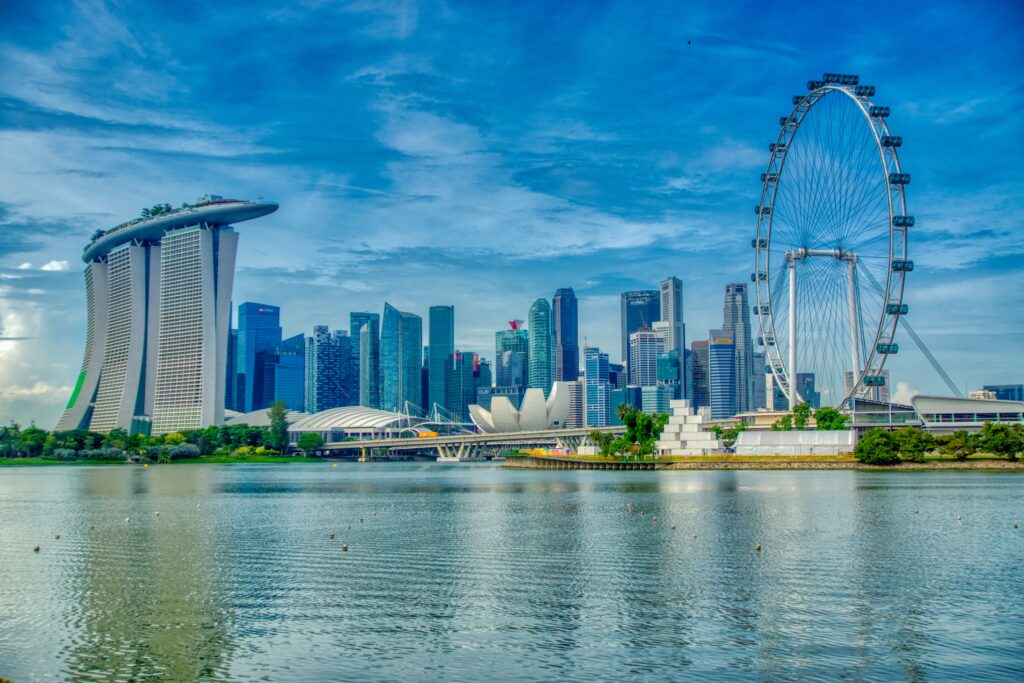 Singapore Flyer, o atracție turistică celebră, în Singapore, vizibilă pe fundalul orașului și lângă apă.