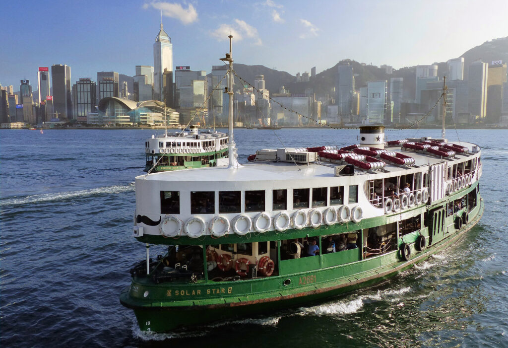 Ferry Star pe apă cu clădiri iconice din Hong Kong în fundal.
