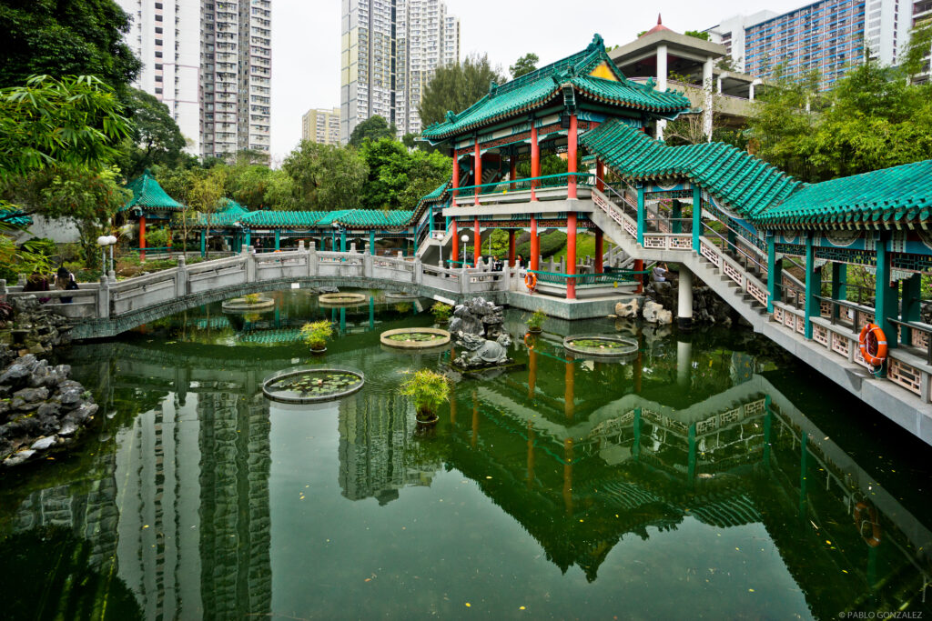 Templele Wong Tai Sin din Hong Kong cu poduri elegante și lac liniștit, un simbol al spiritualității și frumuseții locale.