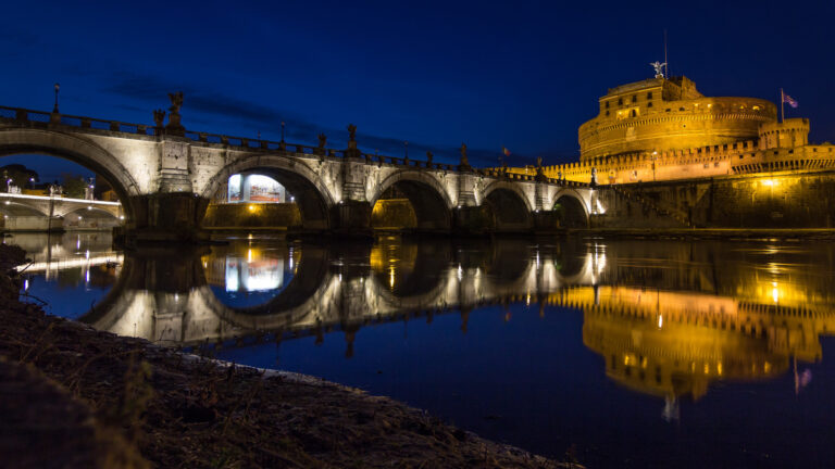 Castel Sant'Angelo din Roma, reflectat în apa râului Tibru, iluminat noaptea.