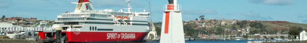 Devonport, Australia, con il traghetto Spirit of Tasmania e il faro iconico in primo piano.