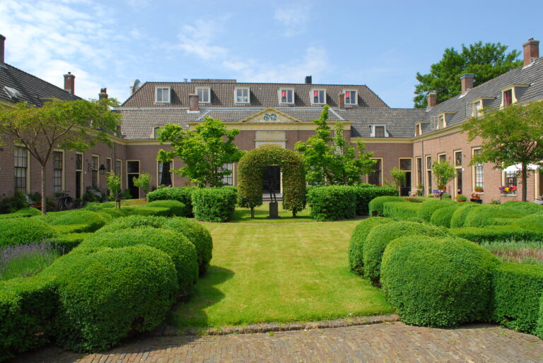 Bellissimo cortile interno con cespugli e edificio principale a Hofje van Oorschot Haarlem.