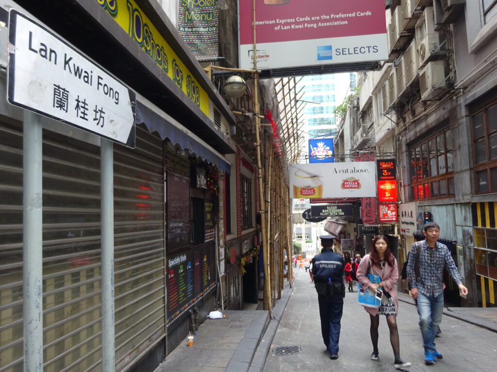 Immagine della strada principale di Lan Kwai Fong a Hong Kong con il caratteristico cartello e la scena vivace.
