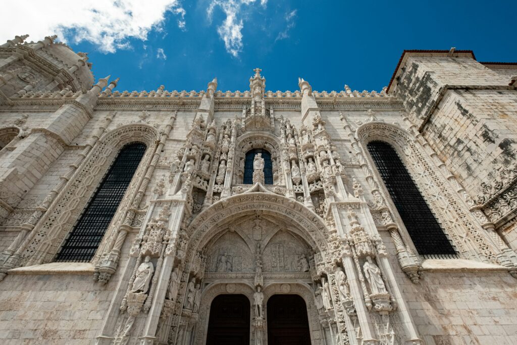 Fațada bogat ornamentată a Mănăstirii Jeronimos sub un cer senin, Lisabona.