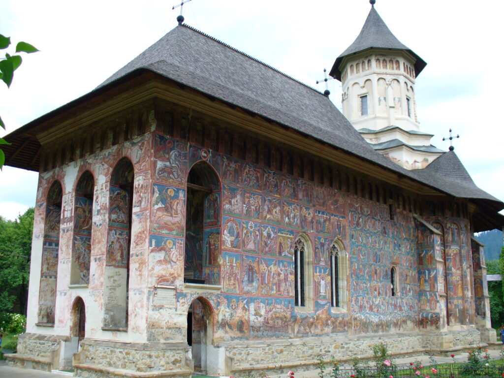 Monastero Moldovita con affreschi dipinti sull'esterno e torre campanaria sullo sfondo.