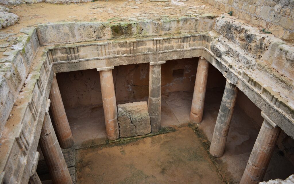 Tombs of the Kings din Paphos, Cipru, cu detalii ale coloanelor antice și o perspectivă aeriană asupra sitului istoric.