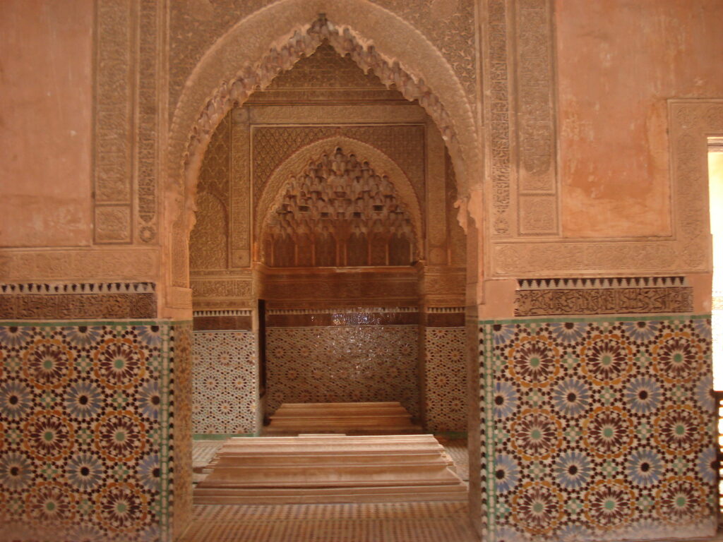 Interno splendidamente decorato delle Tombe Saadiane a Marrakech, con dettagli intricati e mosaici colorati.