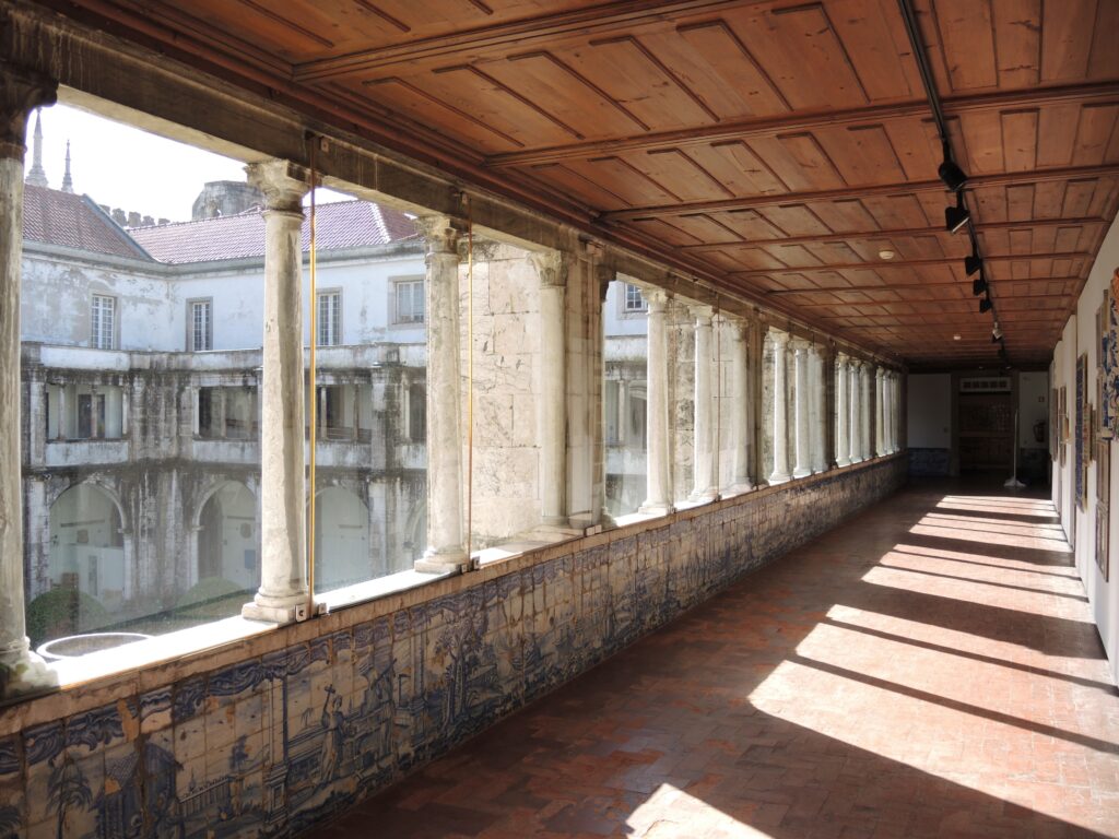 Corridoio con piastrelle di ceramica nel Museo Nazionale della Ceramica di Lisbona, con colonne e soffitto in legno.
