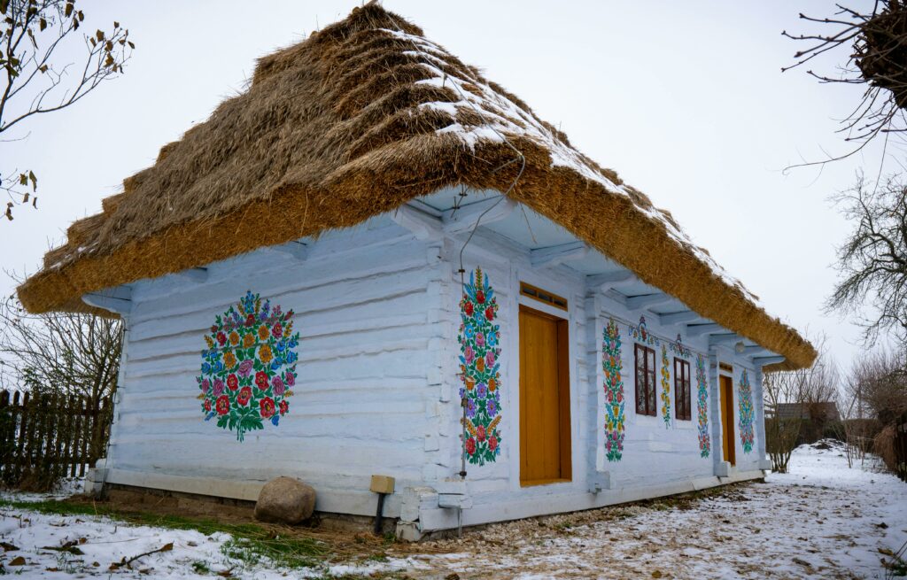 Casă tradițională din lemn cu acoperiș de stuf și picturi florale, Muzeul Satului Bănățean Timișoara.