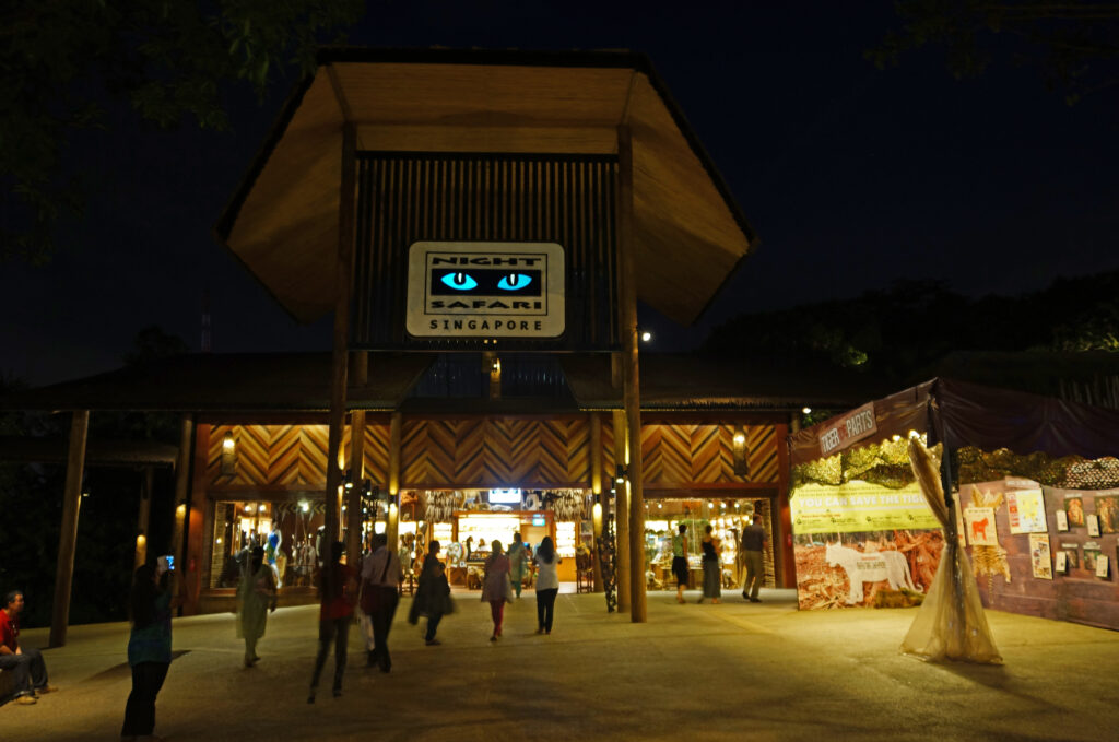 Ingresso Night Safari Singapore con illuminazione notturna e visitatori.