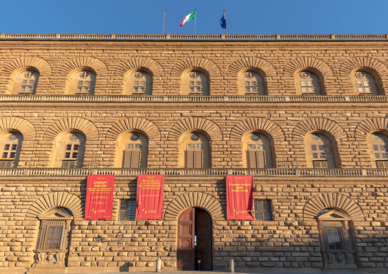 Palazzo Pitti a Firenze, Italia, con la facciata illuminata al tramonto.
