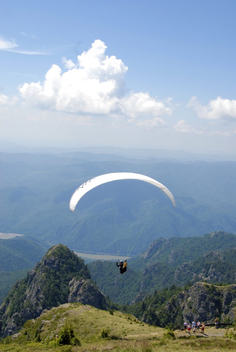 Parapendio che vola sopra le montagne nel Parco Nazionale Cozia.