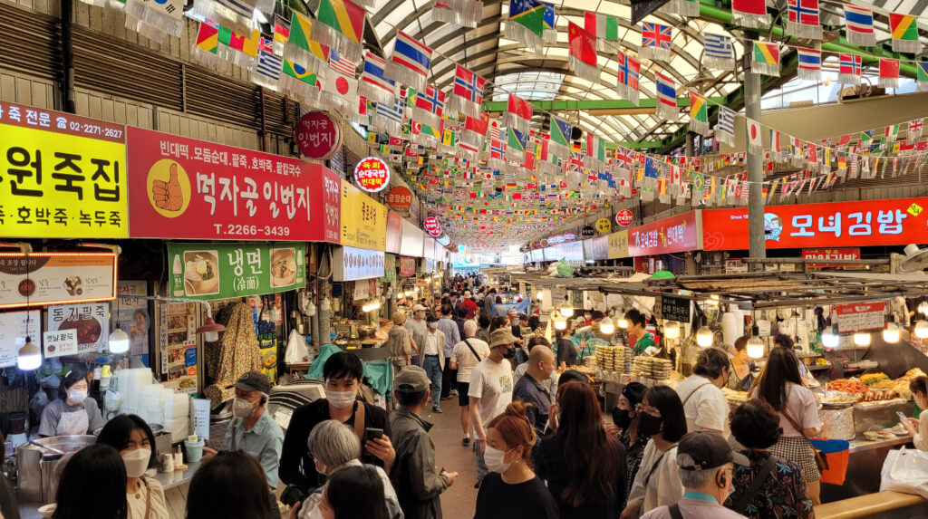 Vista interna del Gwangjang Market di Seoul, piena di attività.