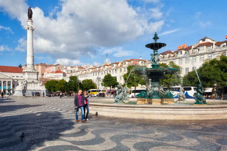 Piazza Rossio Lisbona con la fontana iconica e il monumento centrale sullo sfondo.