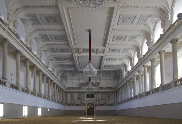 Interno della Scuola di Equitazione Spagnola a Vienna, con illuminazione naturale e dettagli architettonici spettacolari.