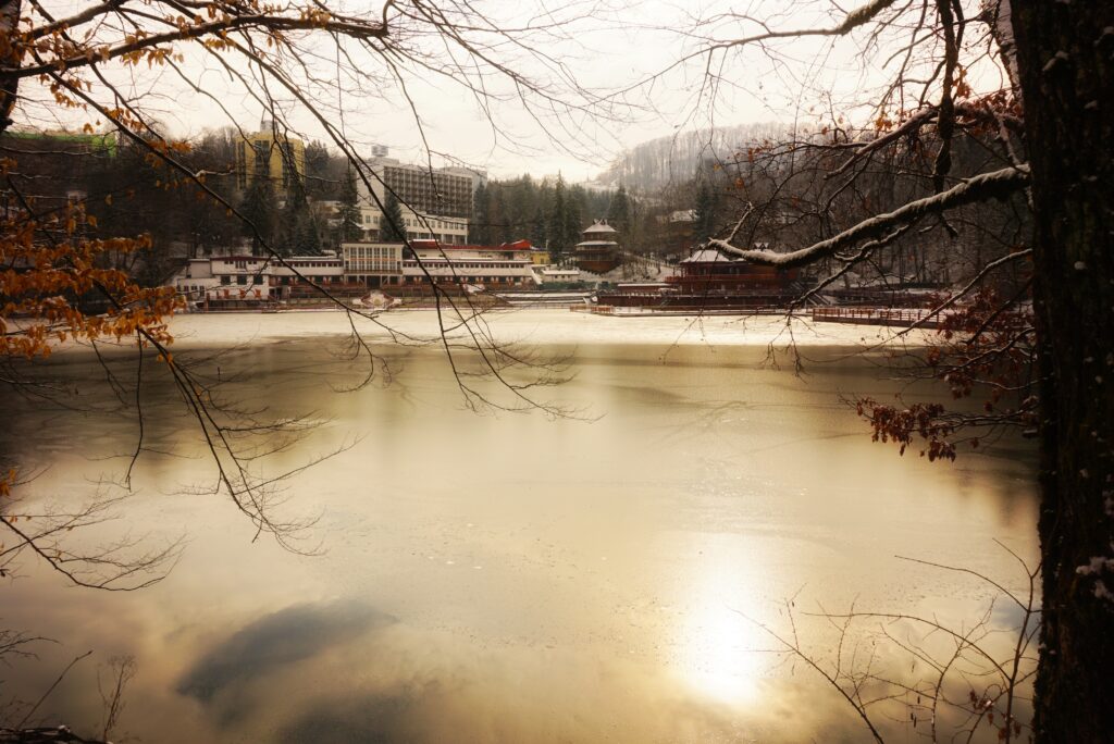 Lacul Ursu din Sovata văzut iarna, cu peisaje pitorești și clădiri turistice pe fundal.