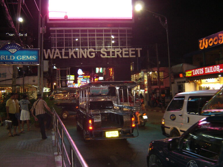 Entrata di Walking Street Pattaya di notte, con insegne luminose e traffico attivo.